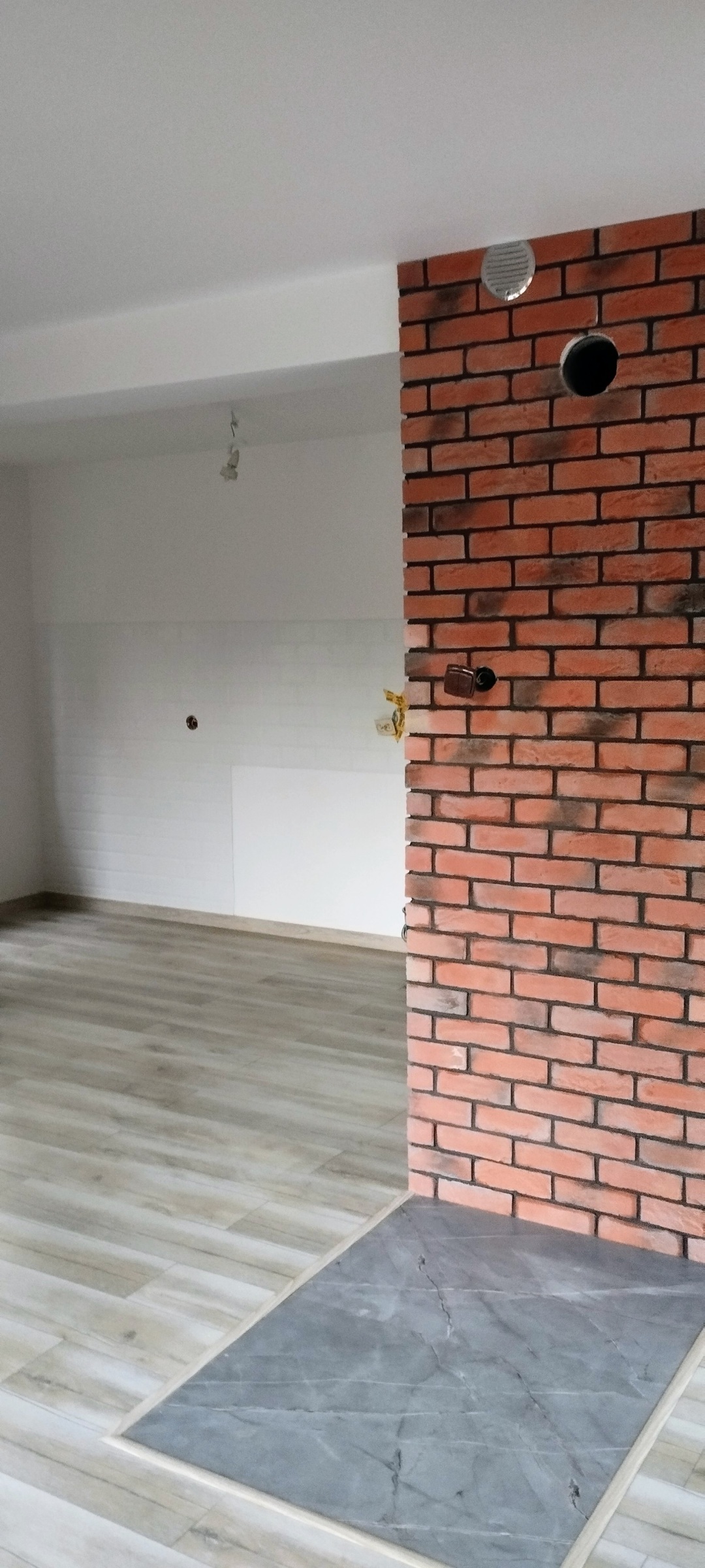 Salon z otwartą kuchnią po remoncie – detal aranżacyjny wnętrza.