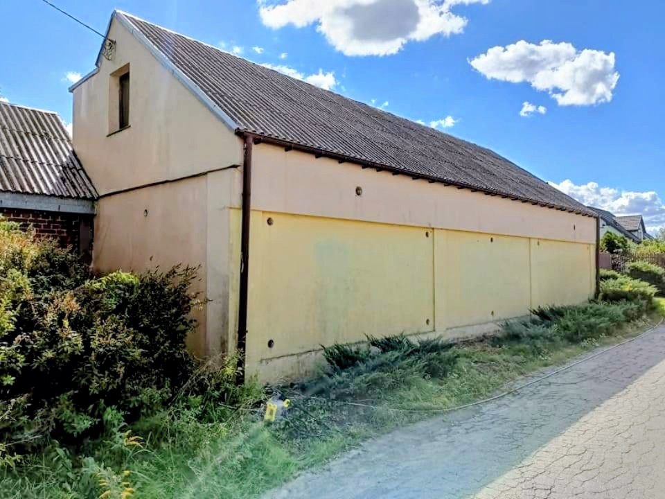 Boczna ściana budynku przed myciem i malowaniem.