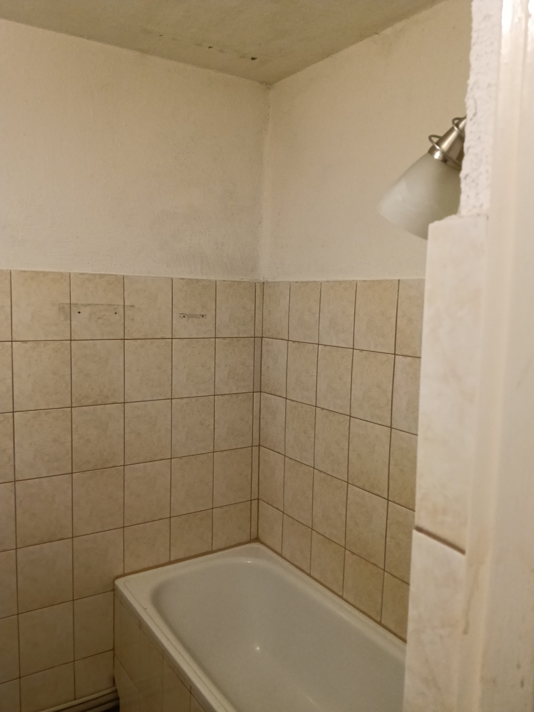 Łazienka przed przebudową – wanna i stara okładzina ścienna.